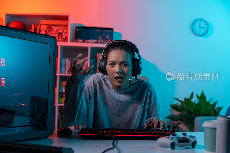 愤怒的年轻亚洲女子在玩电子游戏，输了之后感到很沮丧