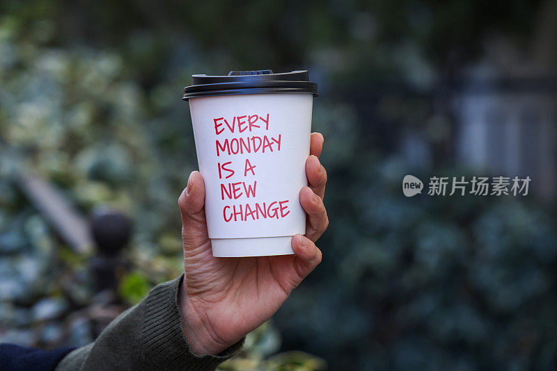 女子拿着可带走的咖啡杯，上面写着“每星期一都是新的改变”