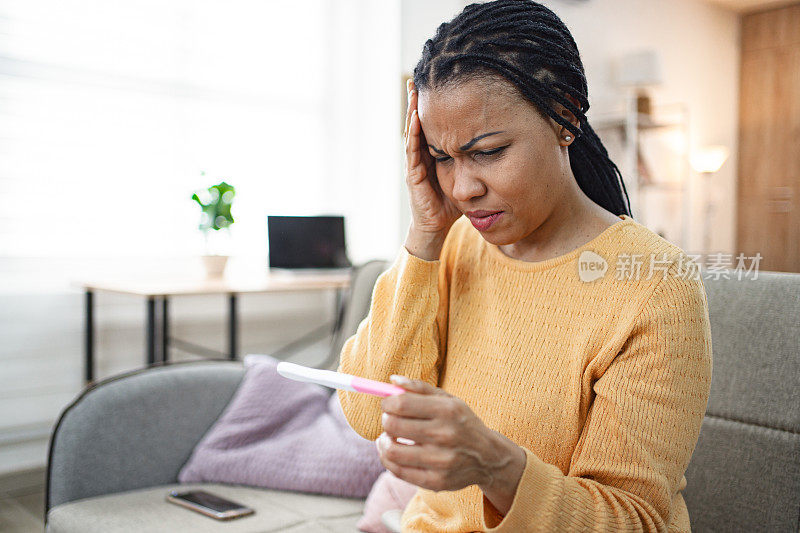 黑人妇女在家里对验孕结果感到不高兴