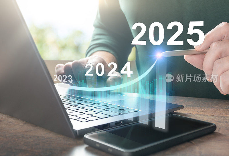 2025年新年。2025年新年商业计划。在笔记本电脑上工作的人绘制了2025年的增长图表。以目标计划、目标理念、行动计划、战略、新年经营愿景开启新的2025年。
