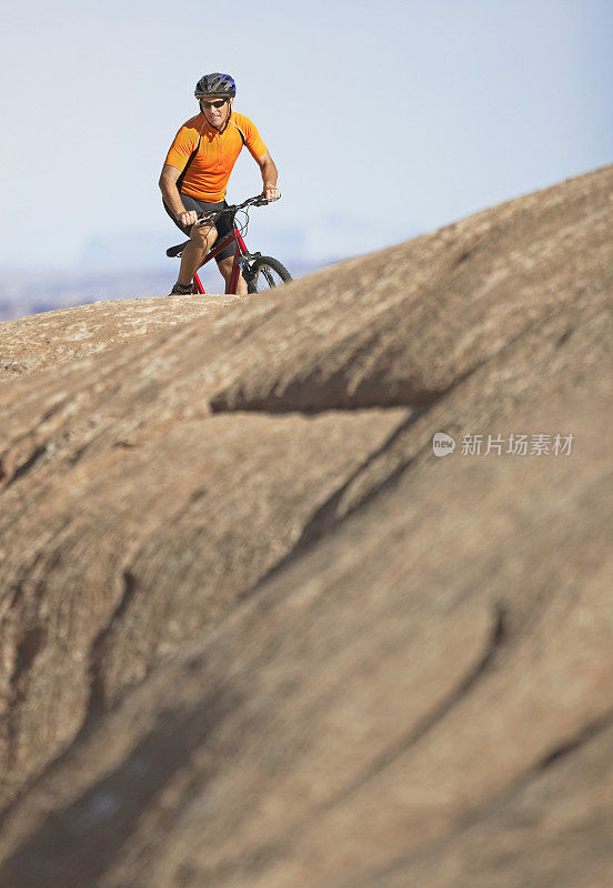 骑自行车的人在石化沙丘的顶部在滑石小径