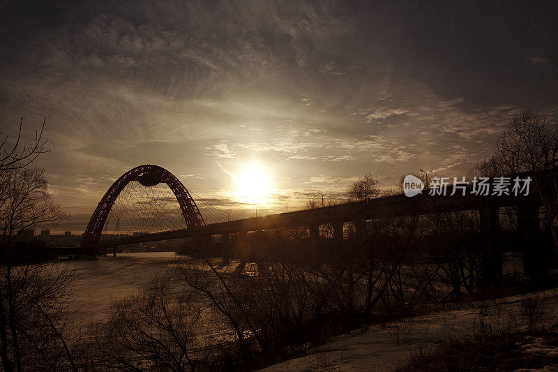 日落时冰封的河上的桥