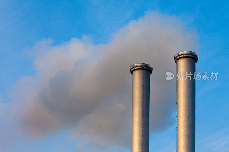 空气污染:两个烟囱在空中释放黑烟