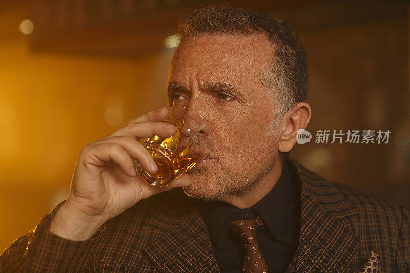 肖像复古浪漫的老男人喝威士忌