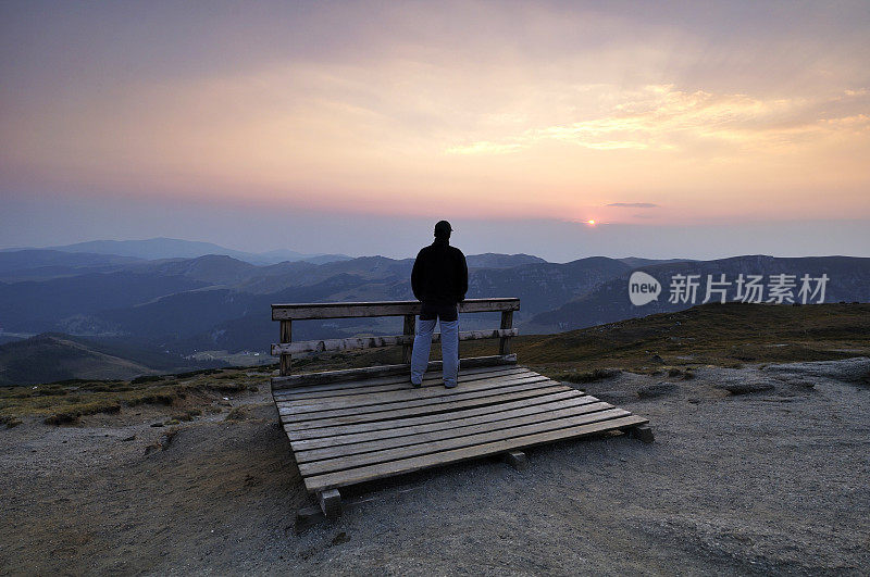 年轻人在山上看日落