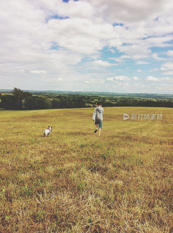 英国牛津郡，一个小男孩和一只狗在草地上