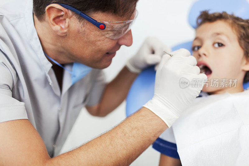 牙科医生张开嘴巴检查孩子。