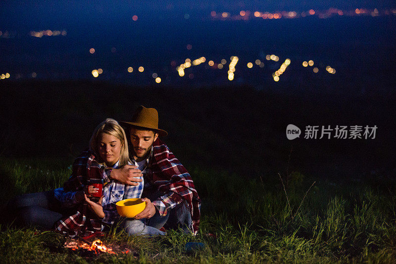 年轻夫妇在大自然中篝火晚会
