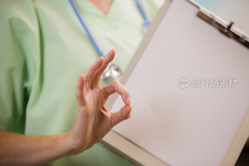 女医生或护士给病人表“OK”的标志。