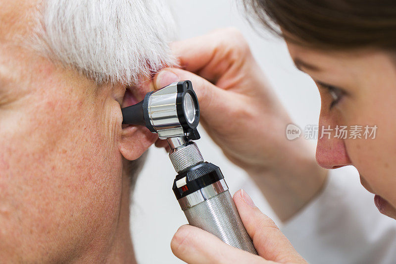 年轻女医生用耳镜检查病人的耳朵