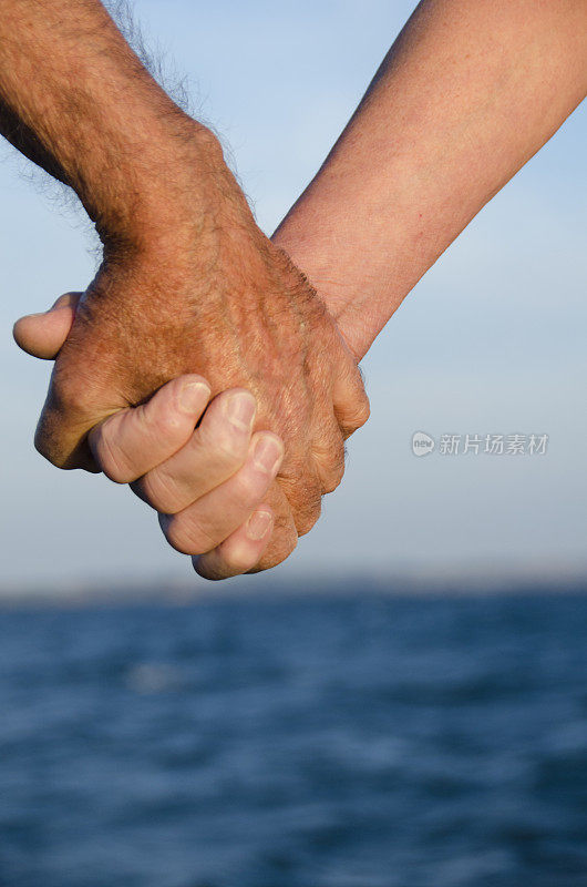 一对老夫妇在海里沐浴后手牵着手