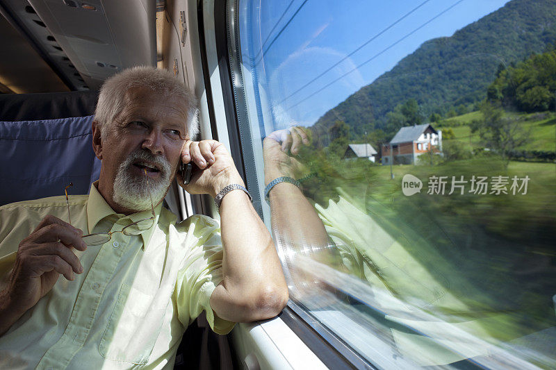 在火车上使用手机的老年乘客