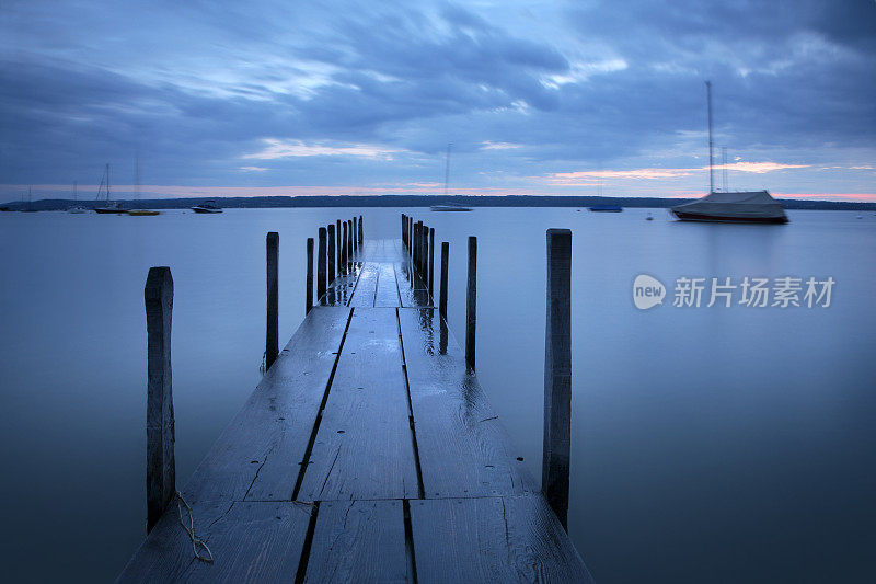 湖泊港口和码头在日落与暴风雨的天空