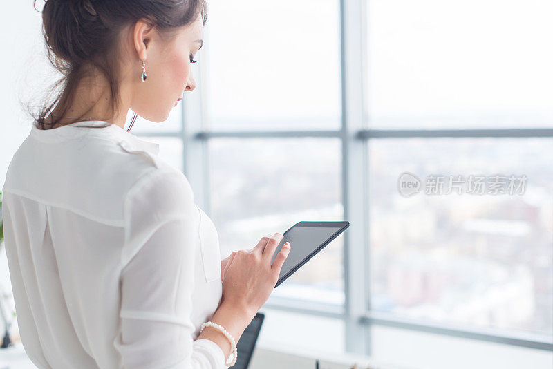 近距离的侧视图肖像的一个员工发短信，发送和阅读信息在她的休息在工作场所。