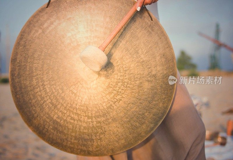 女人拿着木锤打圈钟。锣。的声音疗愈。