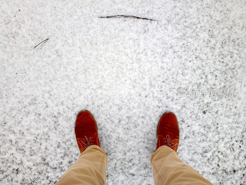 脚踩在雪地里。