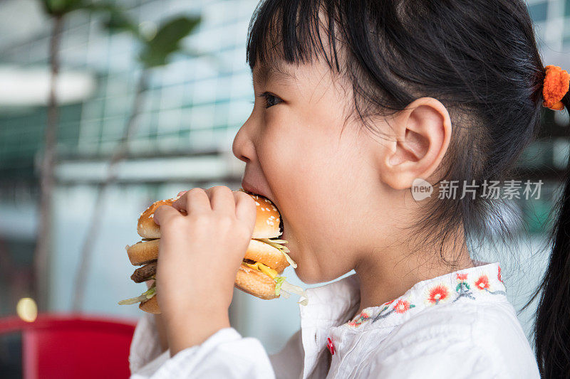 亚洲华人小女孩在吃汉堡