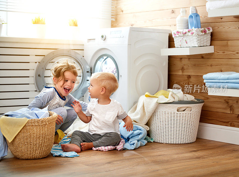 快乐的孩子，男孩和女孩在洗衣机负荷