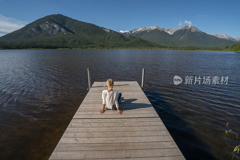 年轻女子在湖边码头凝望大自然