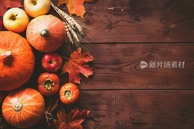 感恩节背景用南瓜、苹果和落叶放在木桌上