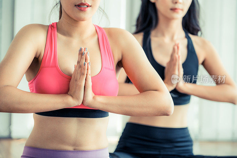 女性在健身健身课上练习瑜伽姿势