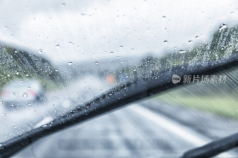 汽车司机POV在潮湿的高速公路上穿过条纹挡风玻璃