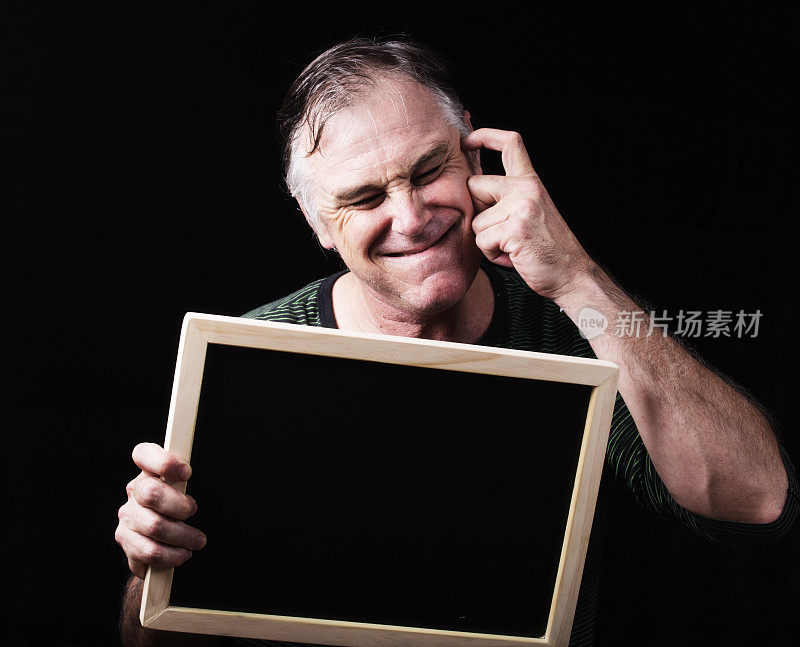 一个男人拿着一块空白的黑板，上面写着抄写空间，同时抓着他的额头