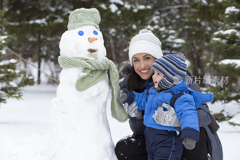 爸爸和妈妈带着他们的孩子，在雪里玩。