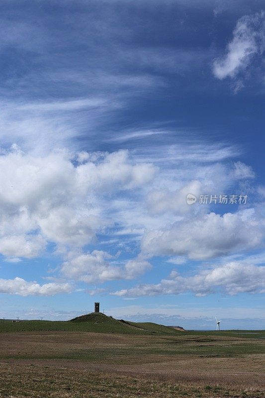 山上的老瞭望塔映衬着蓝天和蓬松的白云