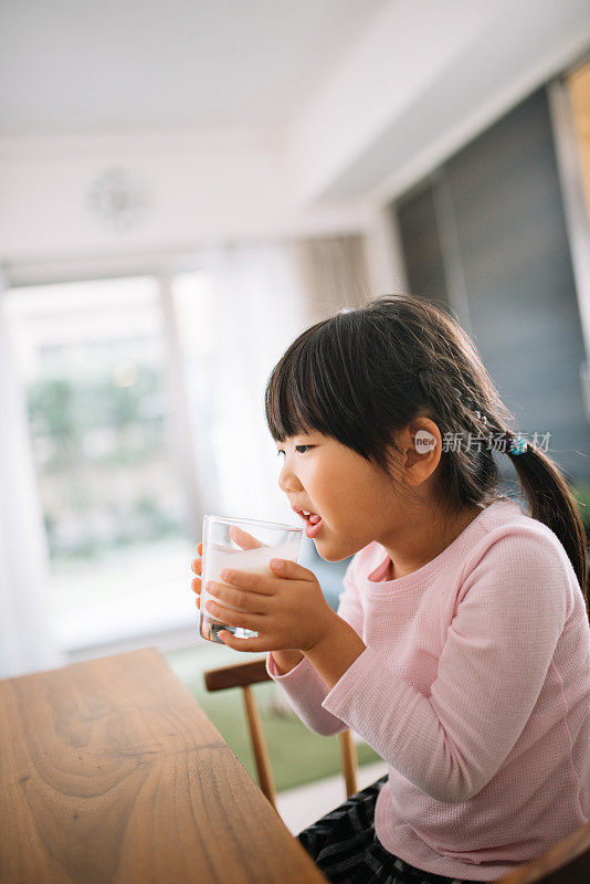 女儿喝着一杯牛奶