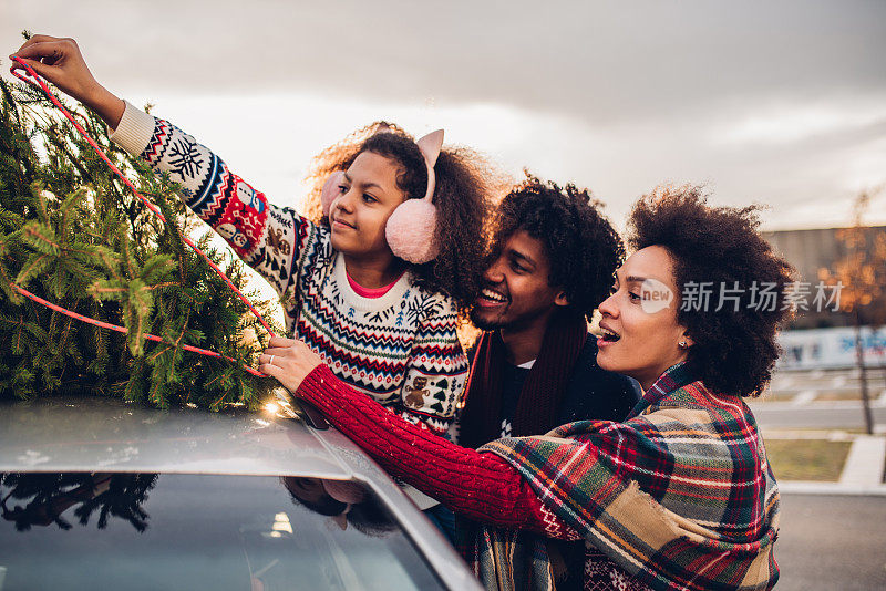 幸福的家庭触摸汽车上的圣诞树