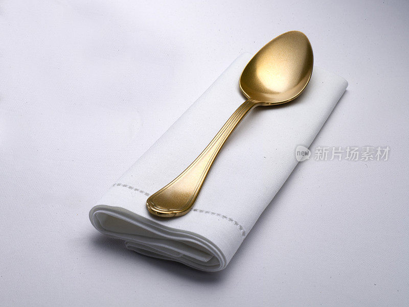 空白的白色餐厅餐巾模型与金色的勺子