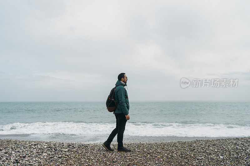 下雨天在海滩上散步的人