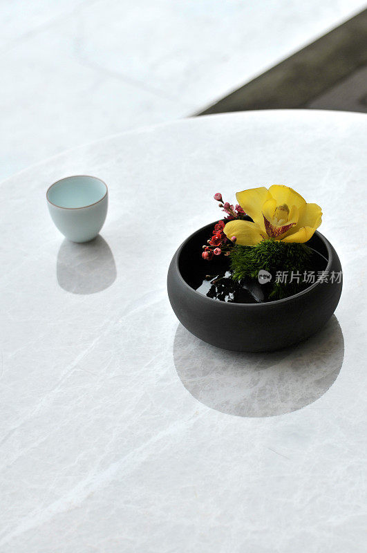 大理石桌上放着花和茶杯
