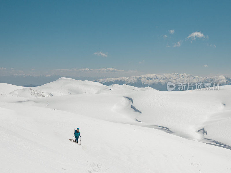 女攀登者正在攀登这座高海拔山峰的顶峰