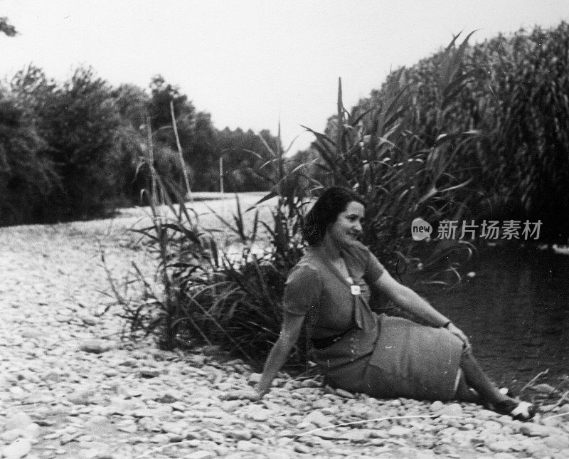 一对穿着考究的夫妇轻松地坐在一条小河边。意大利安科纳,1936.。