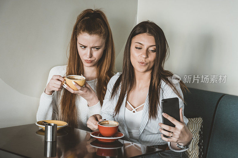 年轻的女性朋友们正坐在Café上拍摄美丽的瞬间