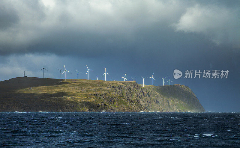 挪威北部波涛汹涌的海面上有风力发电机。Copyspace
