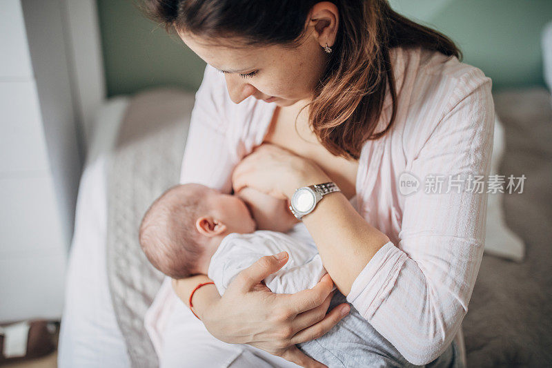 母亲在家里母乳喂养她的男婴