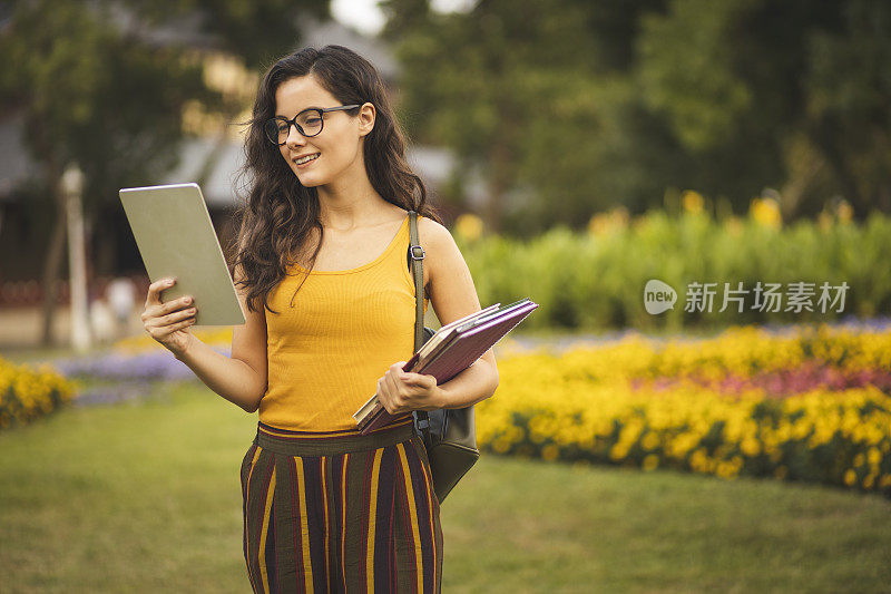 女学生一边做作业一边用平板电脑