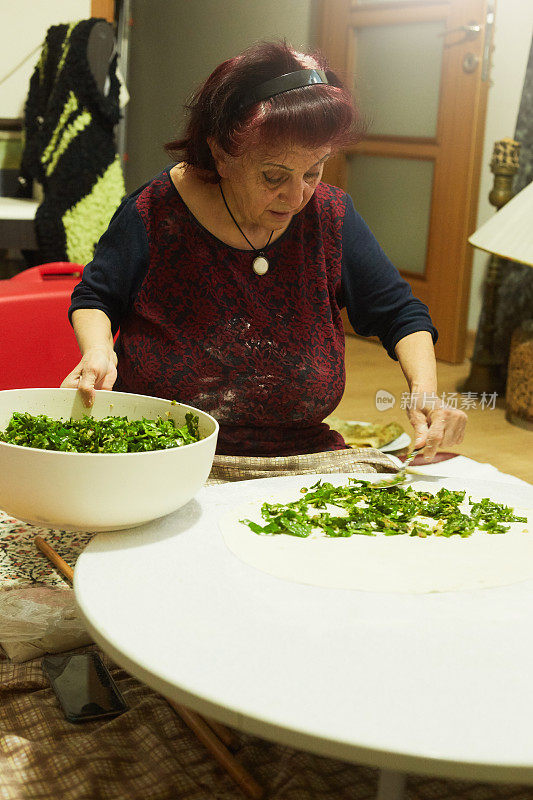 一个女人正在客厅里用电子设备做馅饼