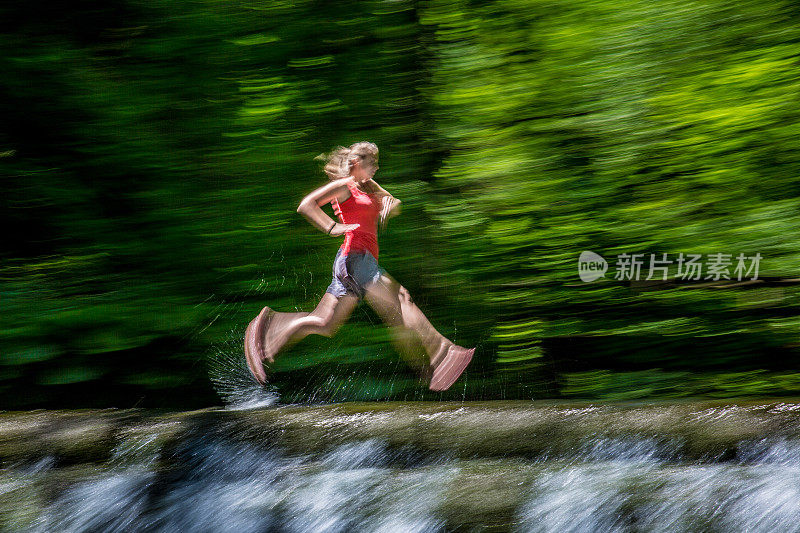 模糊全景拍摄的女子越野跑运动员短跑通过浅滩