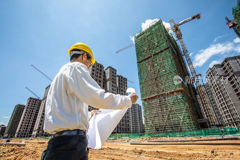 工程师在一个建筑工地看平面图