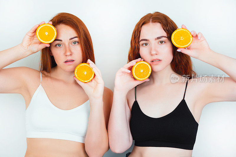 两个红头发的年轻女性都站在孤立的白色背景，其中一半是橙色的头部和另一半是靠近下巴，美丽肖像的概念