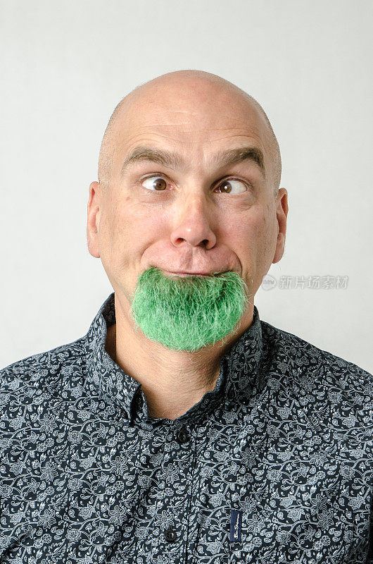 一个光头男人的肖像，下巴上染着绿色的胡须