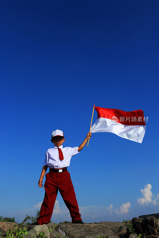 一名小学生举着印尼国旗