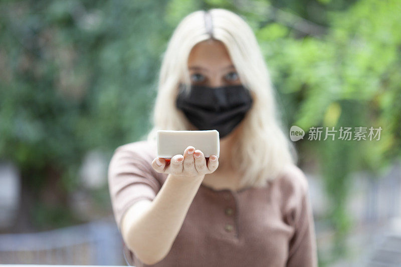 戴黑色面罩的妇女用白色肥皂对抗病毒