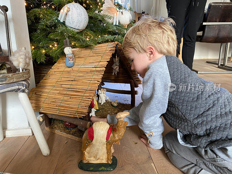 孩子们正在装饰耶稣诞生的场景
