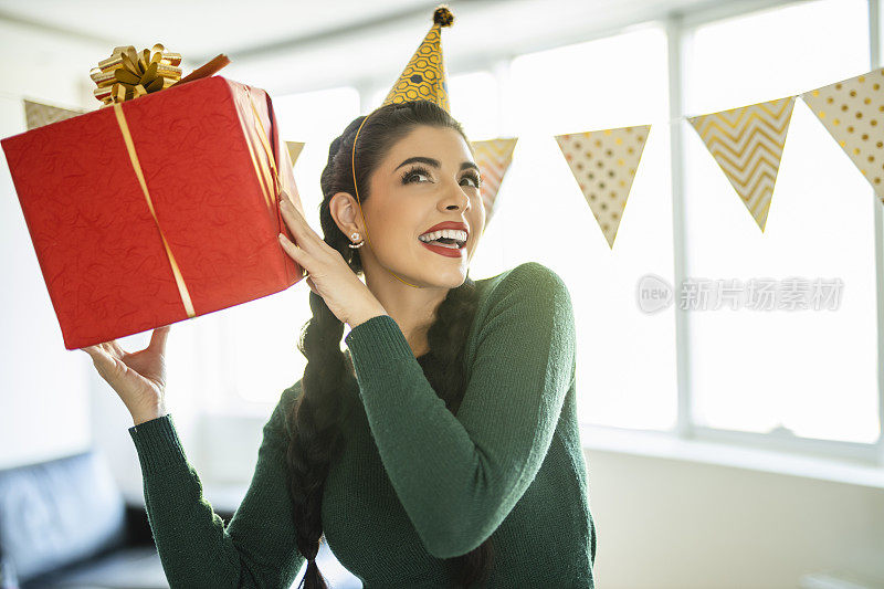 年轻美丽的女人庆祝生日和持有生日礼物的肖像