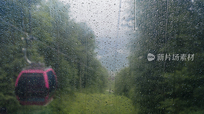 玻璃缆车上的水滴在雨和雾中褪色的背景，但怀旧是清晰的，在一个梦，通过兴奋，美丽仍然令人印象深刻。即使很遥远